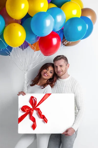 Пара с воздушными шарами и подарок — стоковое фото