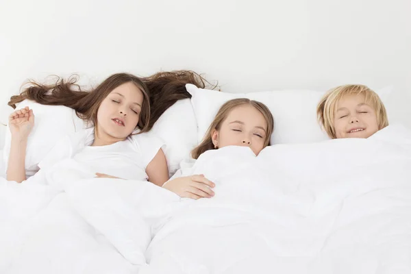Τρία παιδιά στον ύπνο στο κρεβάτι — Φωτογραφία Αρχείου