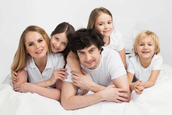 Усміхнена сім'я в ліжку — стокове фото