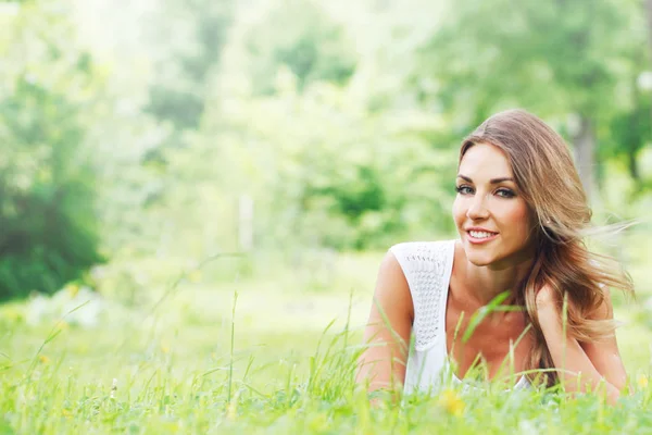 Ung kvinna i vit klänning på gräs — Stockfoto