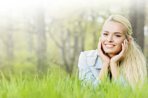 Junge Frau liegt auf Gras — Stockfoto