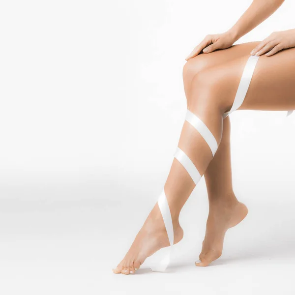 Женские ноги с белой лентой — стоковое фото