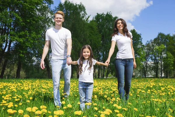 Famille marchant par les fleurs dans le parc — Photo