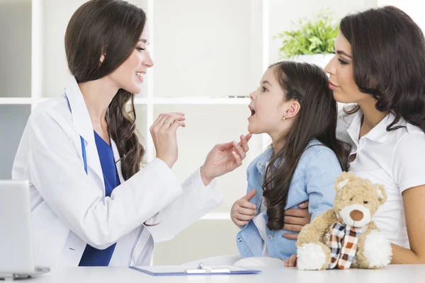 Läkare undersöka barnets hals — Stockfoto