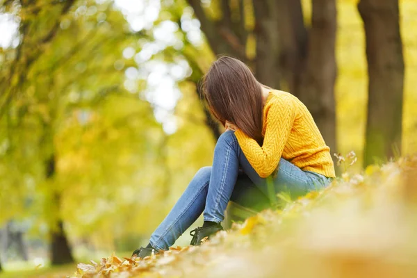 Woman sitting on autumn leaves — Stock Photo, Image