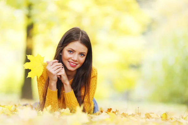 Cute woman laying in autumn park — Stock Photo, Image