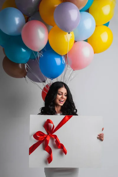 Vrouw met ballonnen en cadeau — Stockfoto