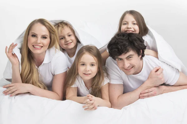 Usmívající se rodina v posteli — Stock fotografie
