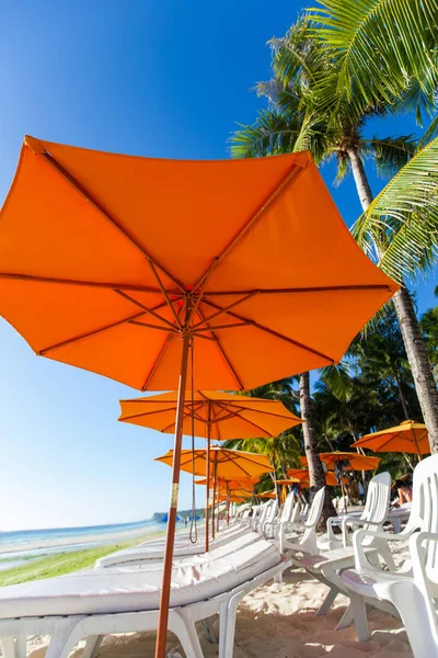 Veel stoelen en parasol op strand — Stockfoto