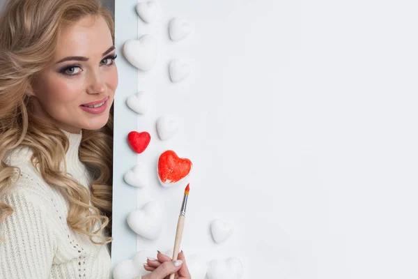 Mujer pintando corazones rojos — Foto de Stock