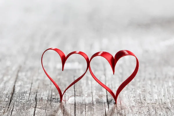 Two ribbon hearts on wood — Stock Photo, Image