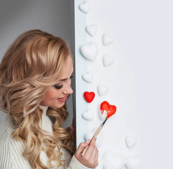 Mujer pintando corazones rojos —  Fotos de Stock