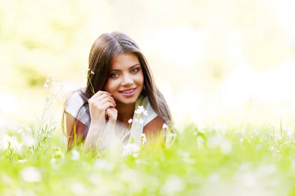 Pretty brunette girl laying on grass — Stock Photo, Image