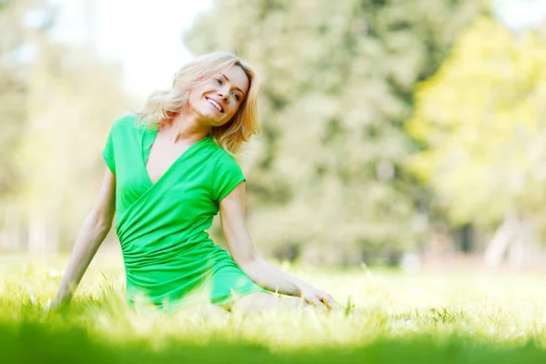 Femme assise sur l'herbe — Photo