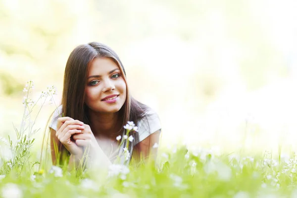 Pretty brunette girl laying on grass — Stock Photo, Image