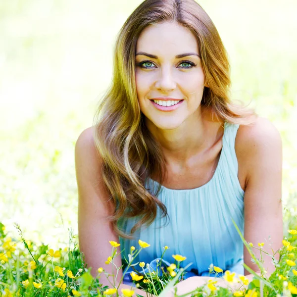 Genç kadın mavi elbiseli çim üzerinde yalan — Stok fotoğraf