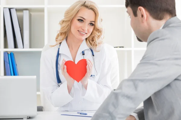 Médico mostrando coração para paciente — Fotografia de Stock