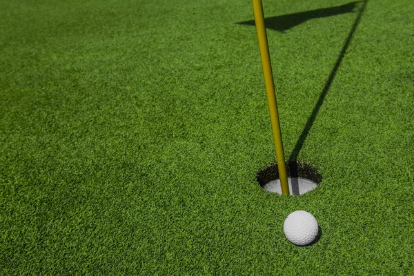 Мяч для гольфа и лунка — стоковое фото
