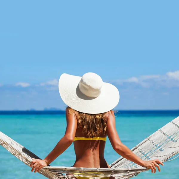 Mujer en sombrero de sol balanceándose en hummock —  Fotos de Stock