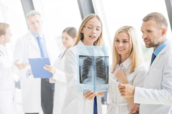 Группа врачей обсуждает рентген — стоковое фото
