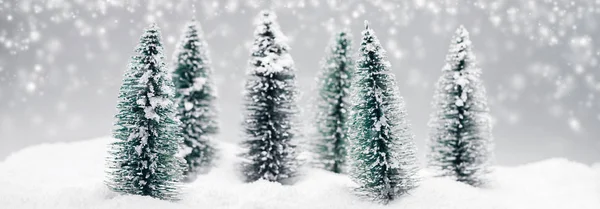 Christmas fir trees at snowfall — Stock Photo, Image