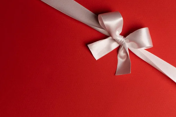 White ribbon bow on red — Stock Photo, Image