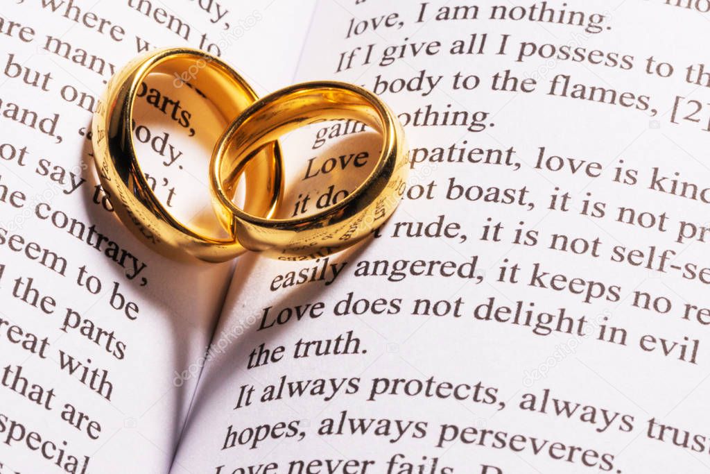 Anillos de boda dorados en el libro de la Biblia Foto de stock yellow2j 329939186