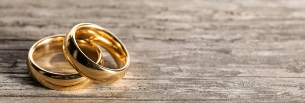 Anéis de casamento dourados em madeira — Fotografia de Stock
