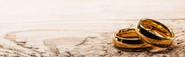 Golden wedding rings on wood clipart