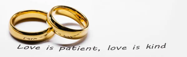 Golden wedding rings on bible phrase