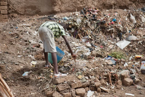 African boy gathering garbage on street — Stock Photo, Image