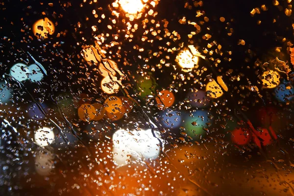 A chuva cai na janela. Bokeh noite cidade . — Fotografia de Stock