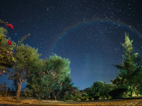 Notte stellata con un debole arcobaleno — Foto Stock