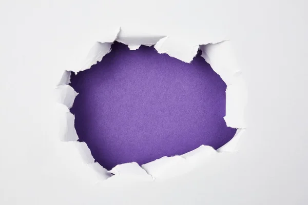 Buraco violeta em papel branco — Fotografia de Stock