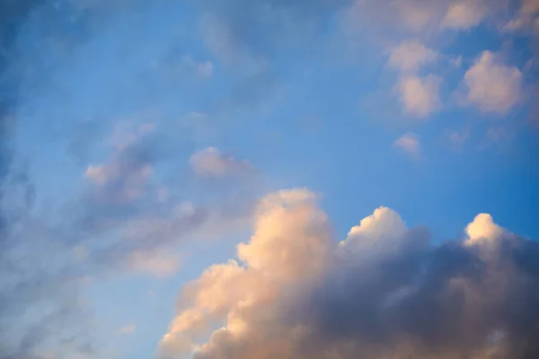 De pluizige wolken bereik op blauwe hemel — Stockfoto