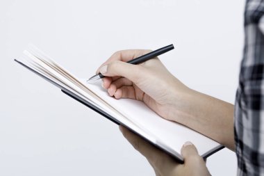 Defter bir kalem yakın çekim kadınlarda'nın ile beyaz bir bac üzerinde eller