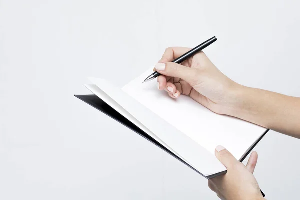 Σημειωματάριο με ένα κοντινό πλάνο στυλό στο των γυναικών στα χέρια ένα λευκό bac — Φωτογραφία Αρχείου