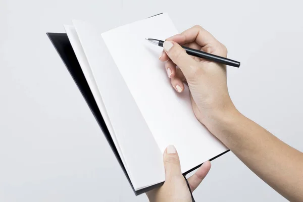 Cuaderno con un primer plano en las manos de las mujeres en un bac blanco — Foto de Stock