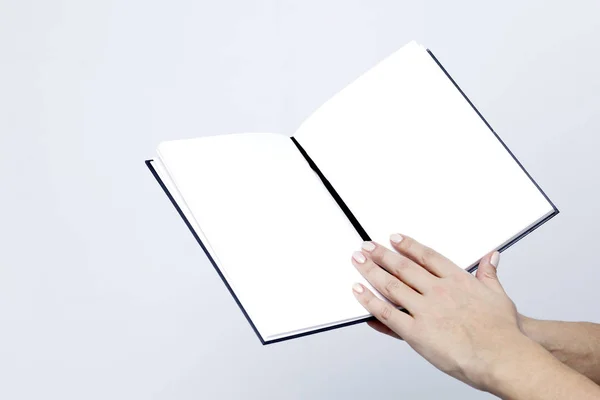 Cuaderno abierto con páginas blancas de cerca en las manos de las mujeres o —  Fotos de Stock