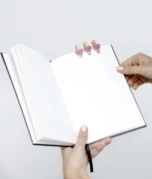 Caderno aberto com páginas brancas close-up nas mãos das mulheres o — Fotografia de Stock