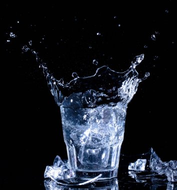 Su sıçramalarına. Düşen buz küpleri bir bardak su bir 
