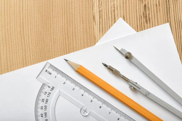 Διάταξη με το μοιρογνωμόνιο, μολύβι και πυξίδα σε λευκό χαρτί — Φωτογραφία Αρχείου