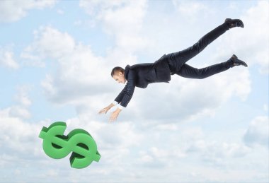 Onun elleri outstreched ile büyük dolar işareti aşağı mavi gökyüzü arka plan üzerinde uçan iş adamı.