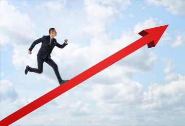 Büyük kırmızı ok yukarı mavi gökyüzü arka plan üzerinde çalışan iş adamı.