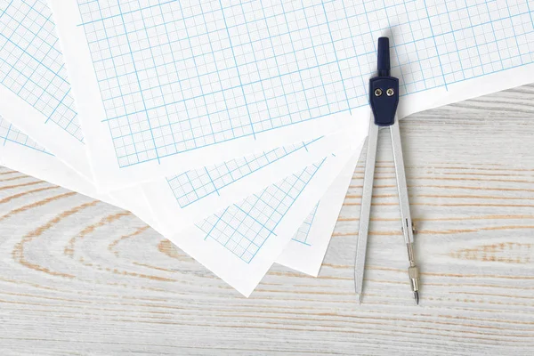 Compass on graph paper in top view with copy space. — Stock Photo, Image