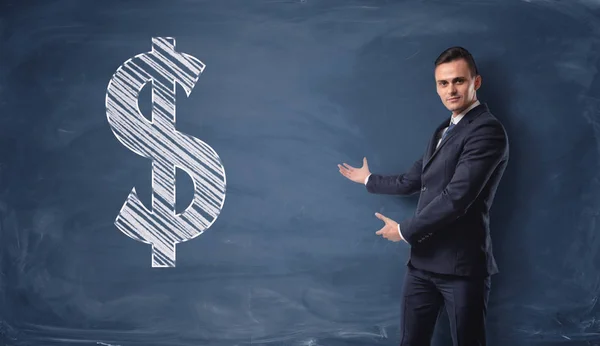 Бізнесмен стоїть і показує знак долара намальований на дошці — стокове фото