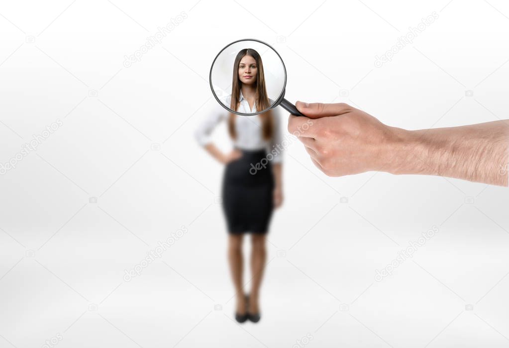 Businesswoman unfocused body and face focused with magnifying glass