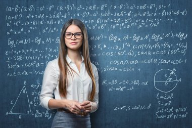 Blackboard matematiksel formüller ile arka plan üzerinde duran genç iş kadını