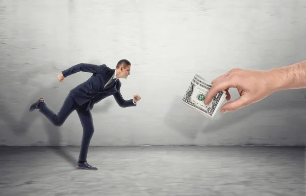 Businessman running for big man hand luring with dollar bill — Stock Photo, Image