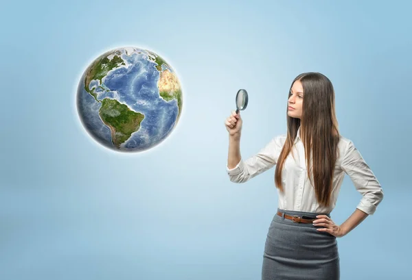 Retrato completo de una mujer de negocios mirando a Globe Earth a través de una lupa . —  Fotos de Stock